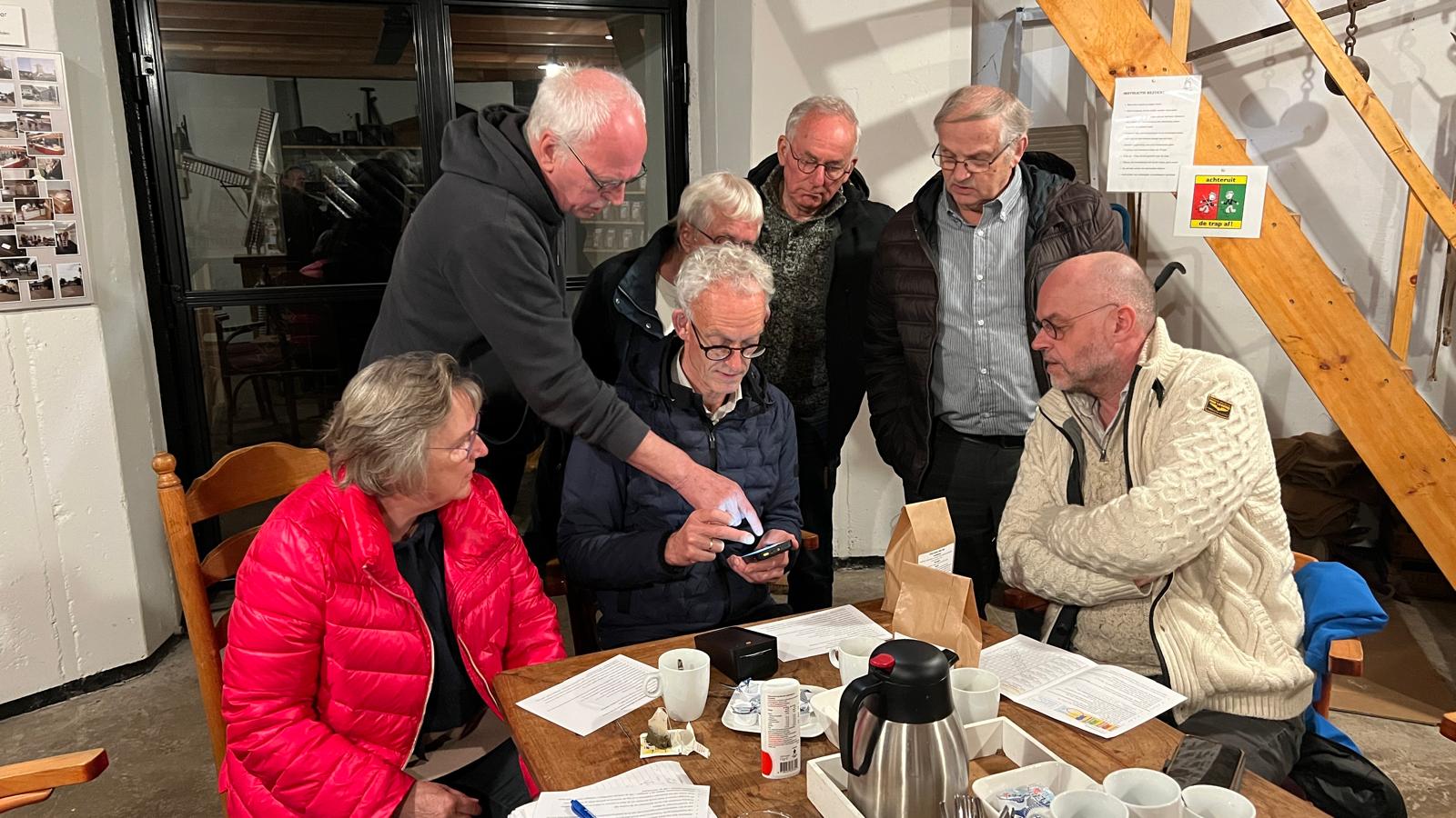 De vrijwilligers van het verkoopteam krijgen uitleg over de barcodescanner.