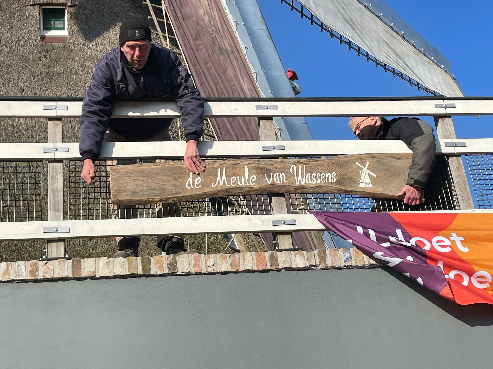 Het nieuwe bord met de naam van de molen prijkt nu trots boven de deur.