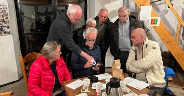 Een deel van de vrijwilligers van het verkoopteam krijgt uitleg over de scanner.